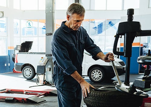 auto mechanic working on a tire