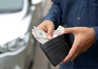 Person takes all of their cash out of their wallet.