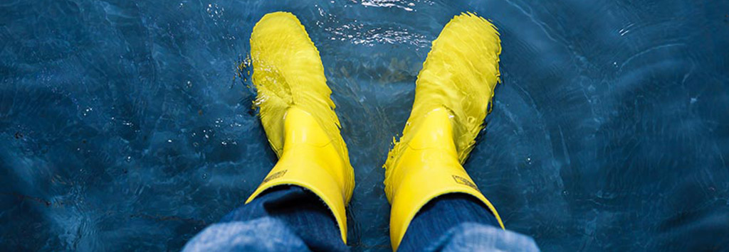 Person wearing rubber boots in standing water