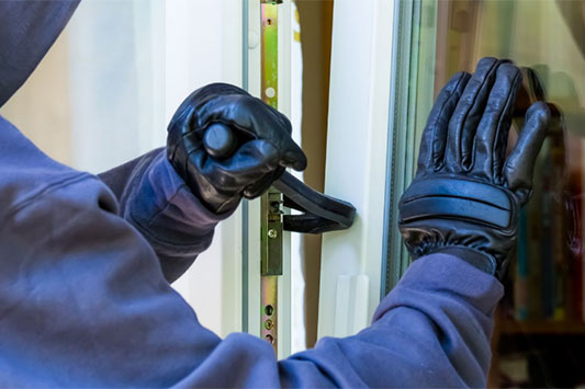 Image of a person breaking into a commercial building.