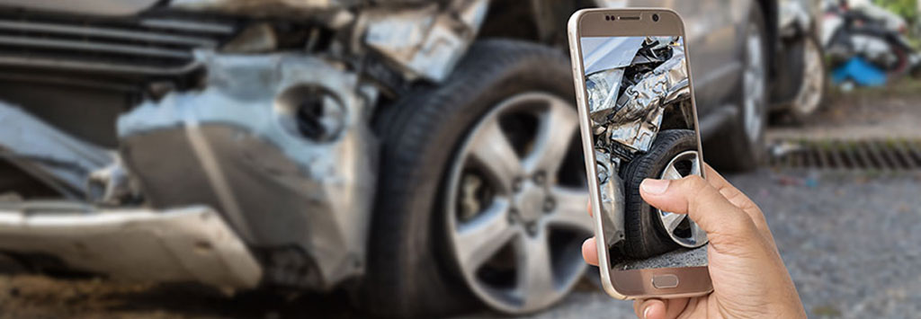 person taking claims pictures of car accident with cellphone