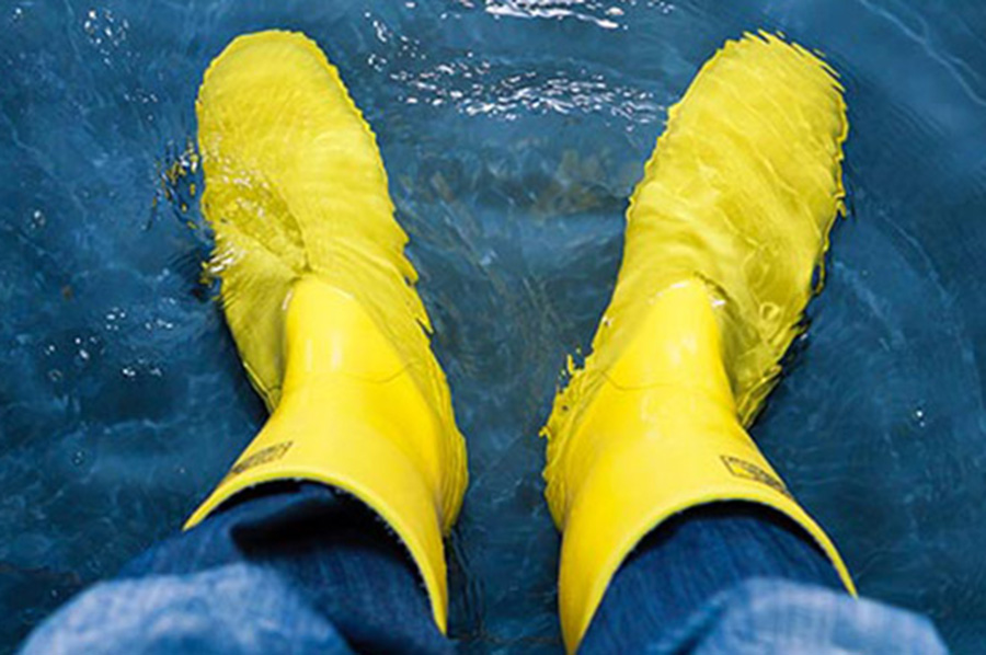 Flood Insurance? Person wearing rubber boots in standing water.