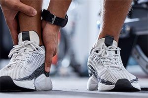 Image of a person holding their injured ankle at their gym.