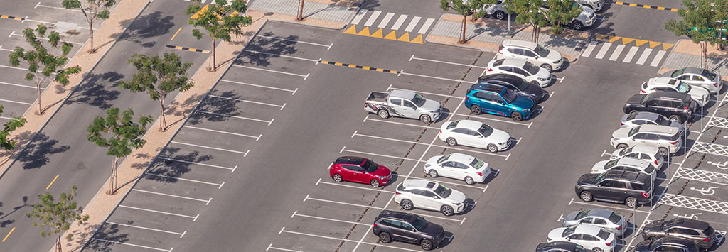 Image of a commercial parking lot with properly marked spots, and pedestrian walkways,