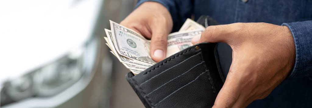 Man holding a wallet and inserting cash
